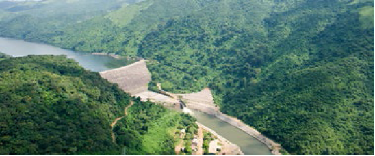 Aerial Photo of a dam with green hills surrounding it.