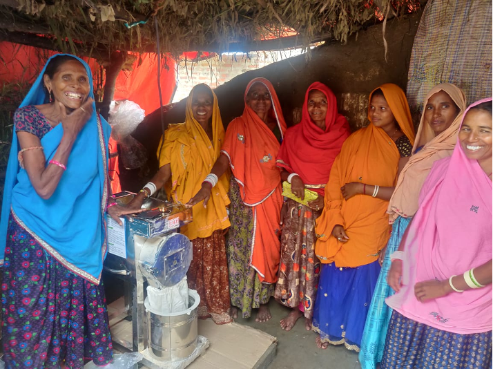 Group of women smiling in front of a newly installed flour mill