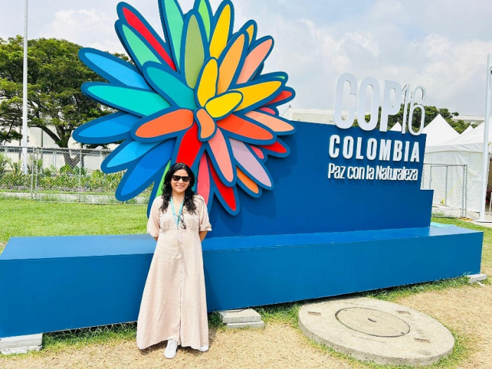 A woman standing in front of the COP16 display in Columbia. 