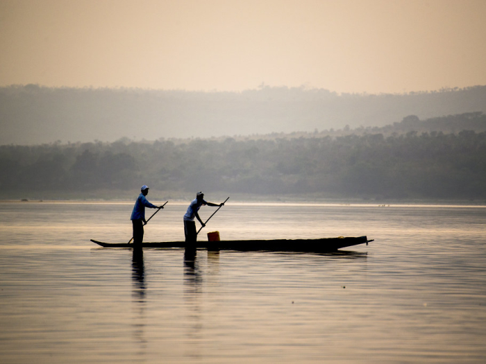 Two individuals rowing a boat through the Congo River between Kinshasa and Lukolela